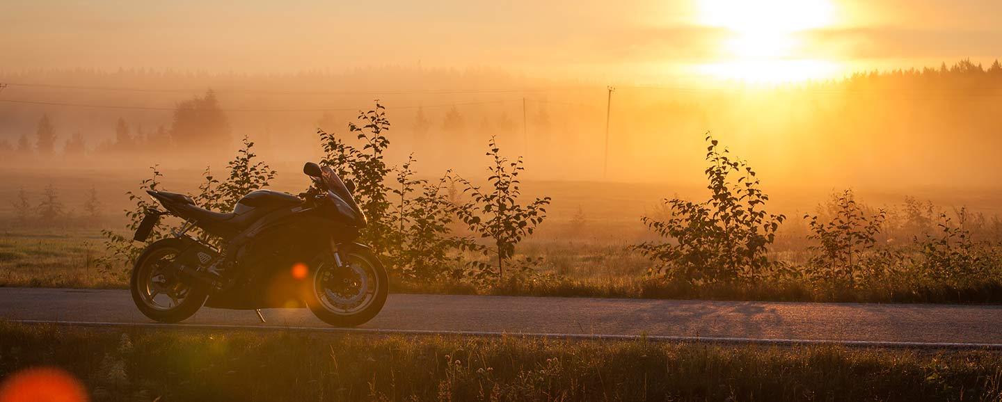 Moottoripyörä parkissa tienvarressa auringonnousun aikaan